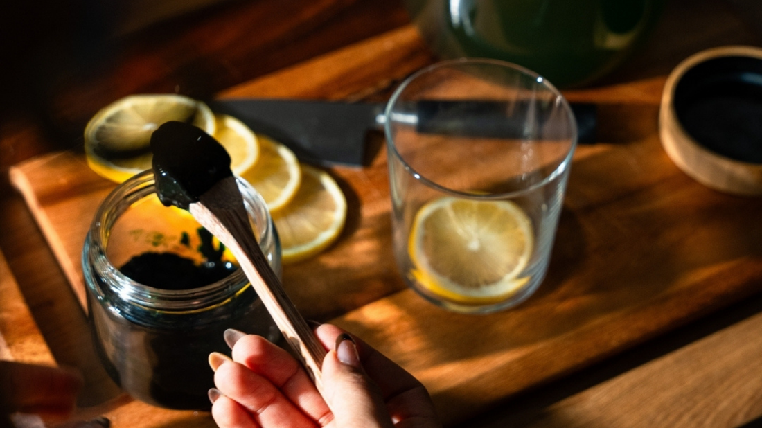 Frische Spirulina Paste wird mit einem Löffel aus dem Glas entnommen