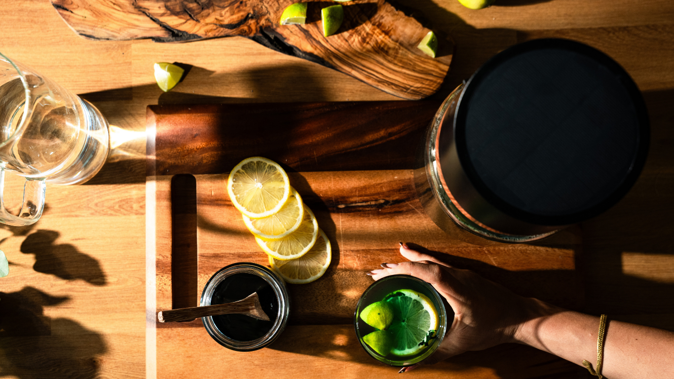 Zubereitung von frischem Spirulina-Wasser mit Zitrone auf einem Holzbrett